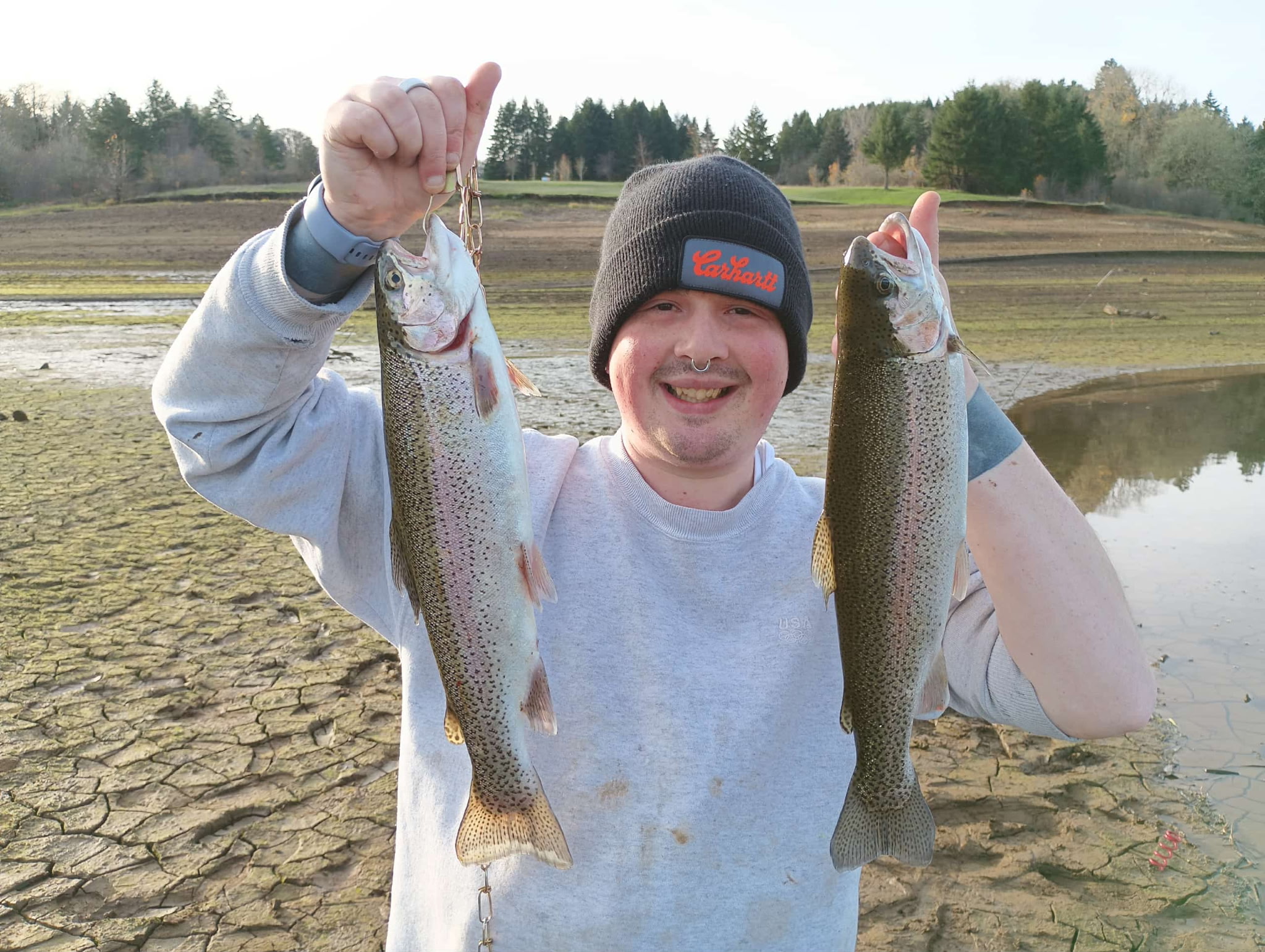 Allan holding two rainbow trout at a PNW lake